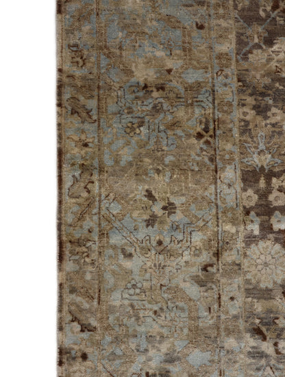 A hand-knotted silk and wool rug featuring a traditional and contemporary coastal design with natural tones of brown, taupe, light blue, grey, and ivory.