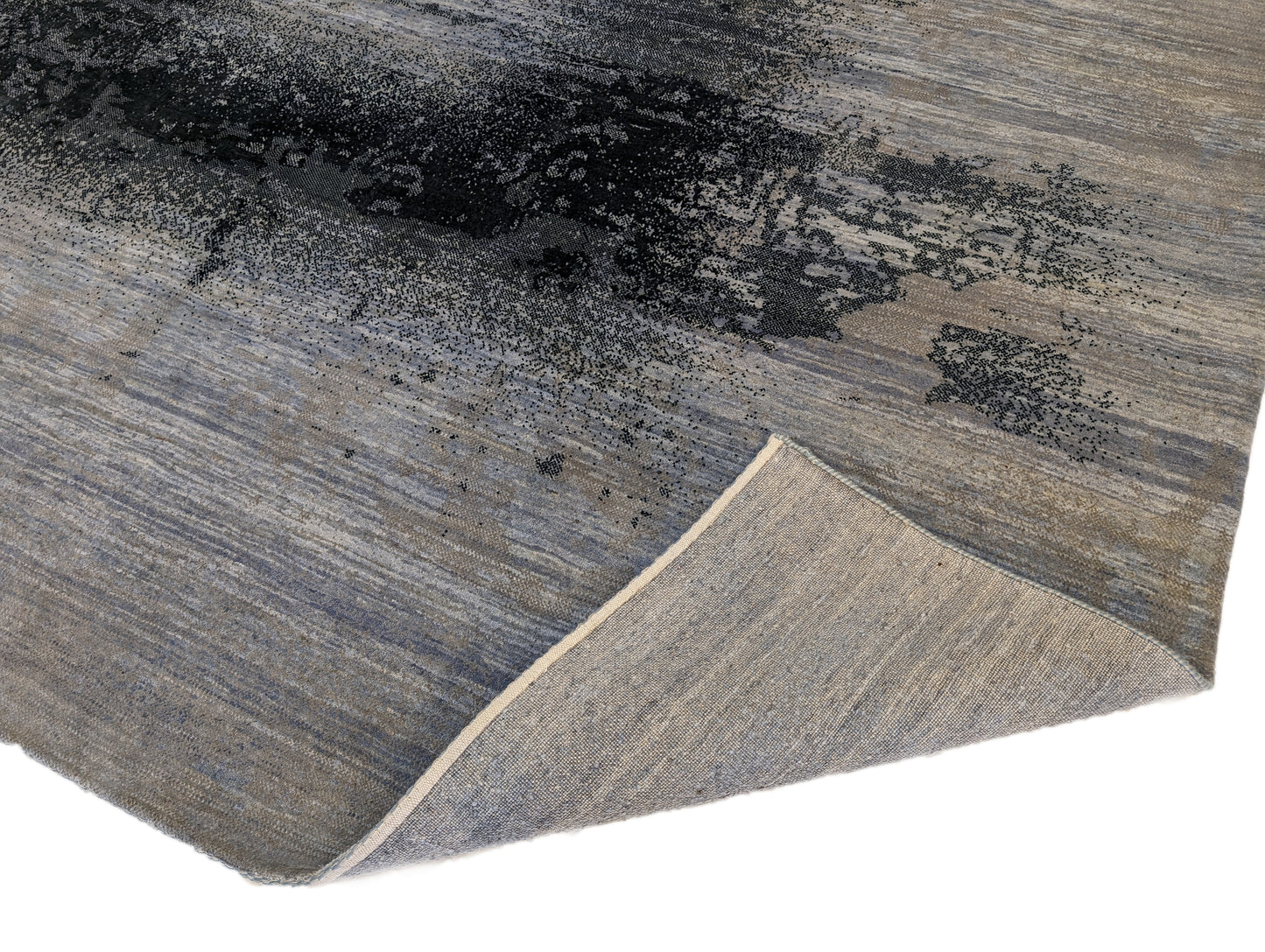 A hand-knotted rug with a serene coastal aesthetic featuring shades of gray, blue, and green, and a unique hand-knotted design. Cozy wool and luxurious silk. 