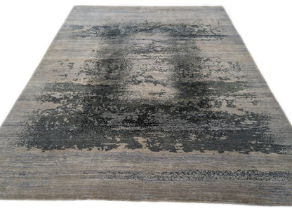 A hand-knotted rug with a serene coastal aesthetic featuring shades of gray, blue, and green, and a unique hand-knotted design. Cozy wool and luxurious silk. 