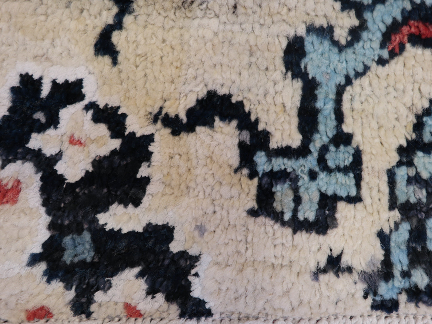 A hand-knotted rug with a coastal aesthetic, featuring a larger knot and higher pile. It has a vivid palette of turquoise, coral, and navy, with serene tones of ivory and white.