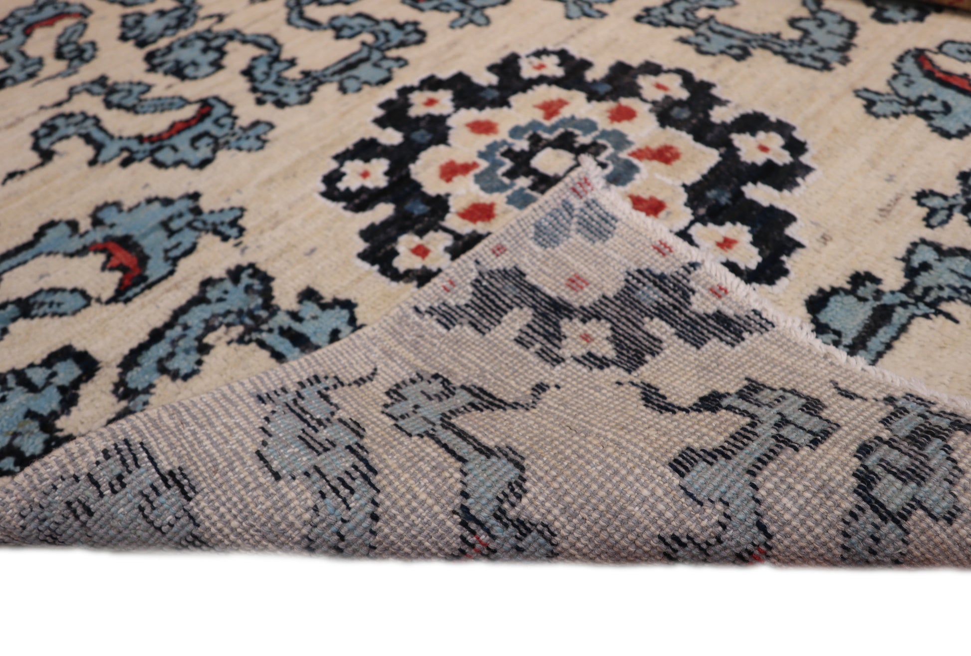 A hand-knotted rug with a coastal aesthetic, featuring a larger knot and higher pile. It has a vivid palette of turquoise, coral, and navy, with serene tones of ivory and white.