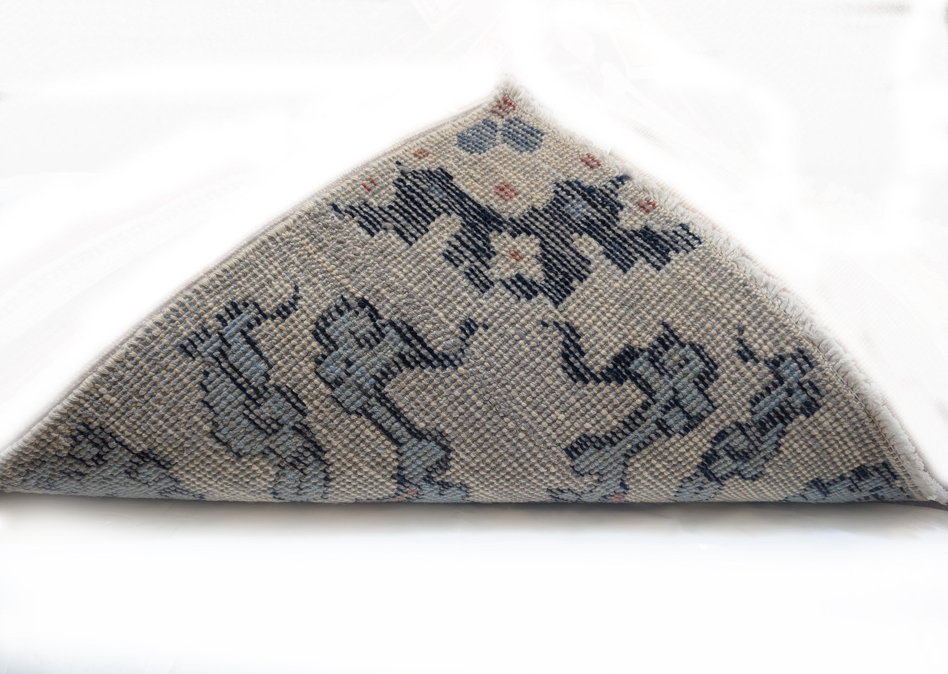A hand-knotted rug with a coastal aesthetic, featuring a larger knot and higher pile. It has a vivid palette of turquoise, coral, and navy, with serene tones of ivory and white.