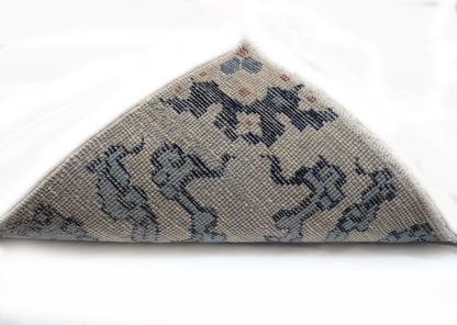 A hand-knotted rug with a coastal aesthetic, featuring a larger knot and higher pile. It has a vivid palette of turquoise, coral, and navy, with serene tones of ivory and white.