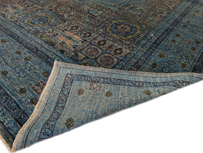 A hand-knotted wool rug with a vivid palette of colors including turquoise, orange, green, eggplant, grey, and navy, featuring intricate tribal patterns.