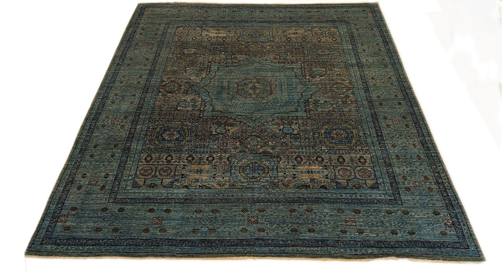 A hand-knotted wool rug with a vivid palette of colors including turquoise, orange, green, eggplant, grey, and navy, featuring intricate tribal patterns.