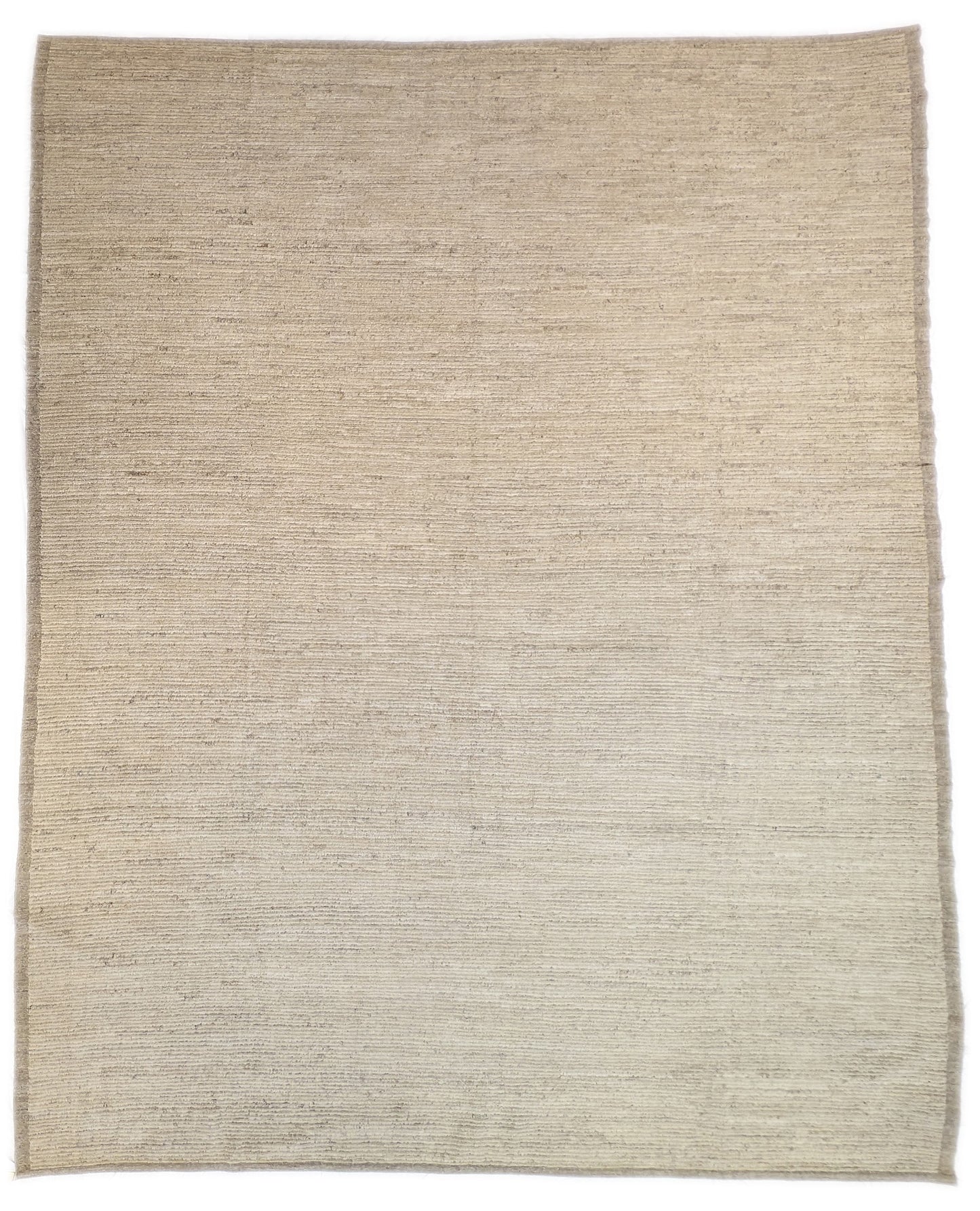 A hand-knotted wool rug in beige, ivory, and cream colors with a coastal aesthetic and a plush appearance.