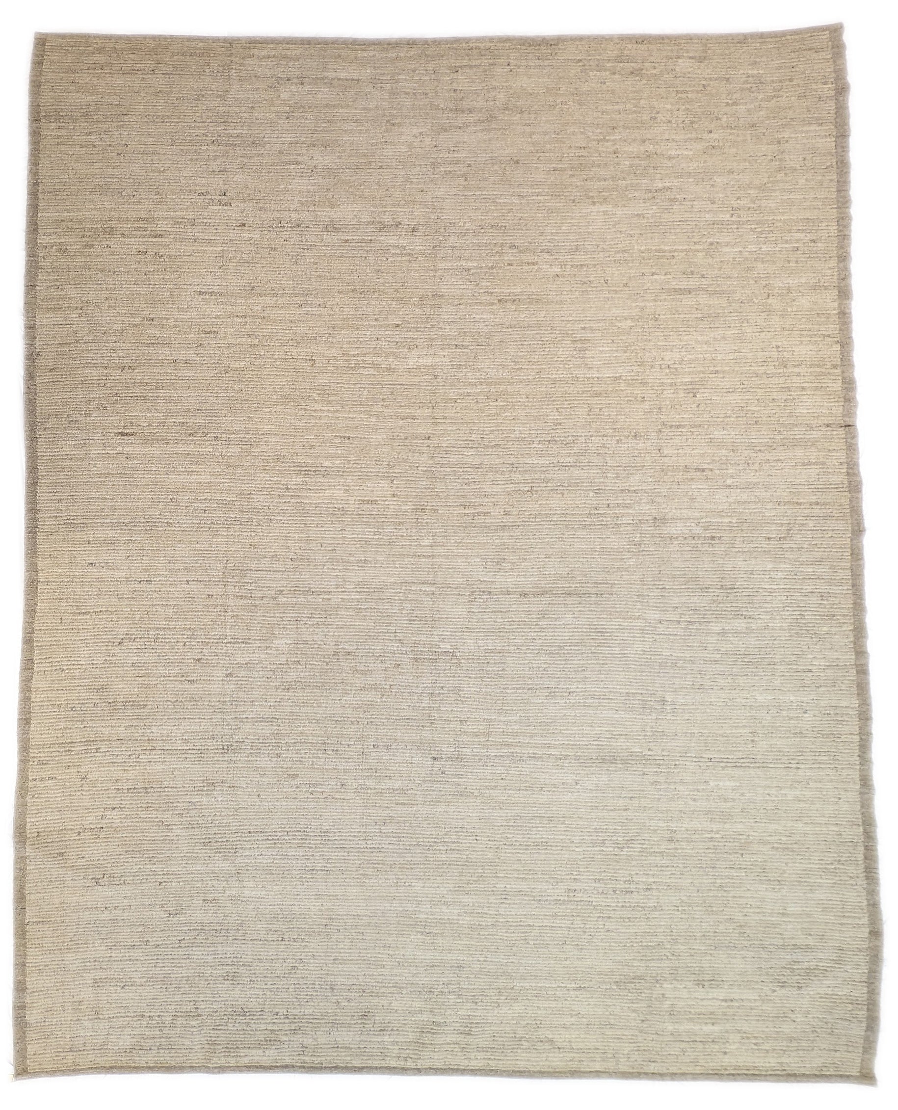 A hand-knotted wool rug in beige, ivory, and cream colors with a coastal aesthetic and a plush appearance.