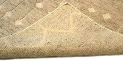 Hand-knotted neutral wool rug from Nepal with a high-low pile and large knots in shades of beige, ivory, and cream.