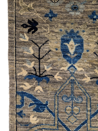A hand-knotted wool rug with a coastal color palette, featuring traditional and contemporary geometric patterns.