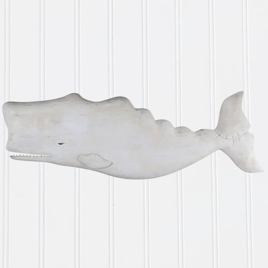 Decorative whale wall art on a white paneled wall