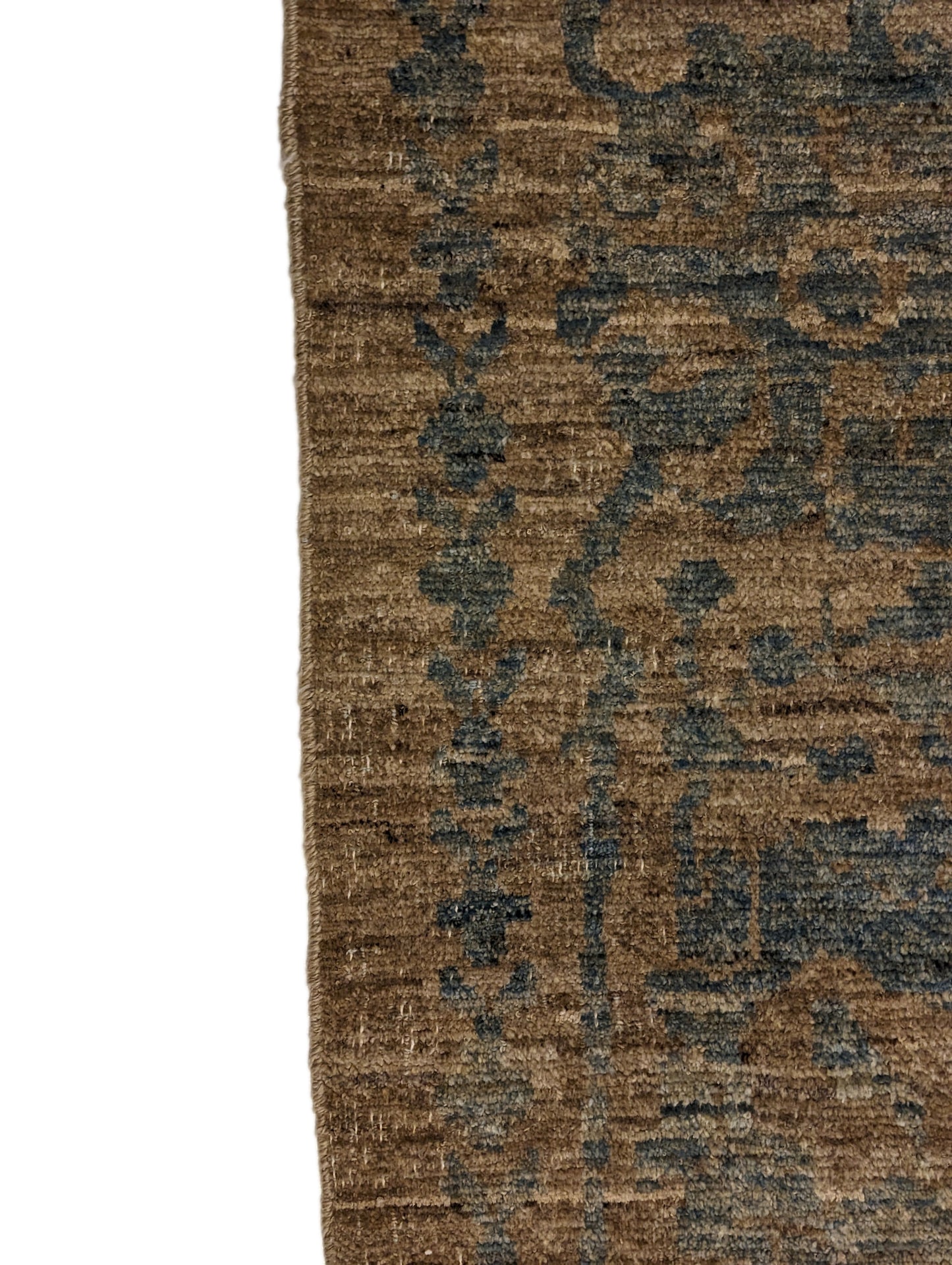 A hand-knotted low pile wool rug with a coastal-inspired design in natural tones of sandy brown and a subtle hint of aquamarine.