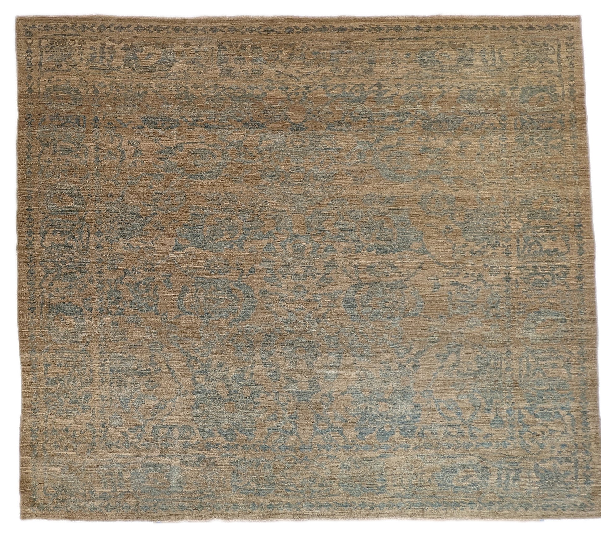 A hand-knotted low pile wool rug with a coastal-inspired design in natural tones of sandy brown and a subtle hint of aquamarine.