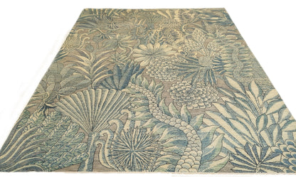 A hand-knotted wool rug with a coastal-inspired floral and plant design in shades of beige, gray, blue, green, and black.