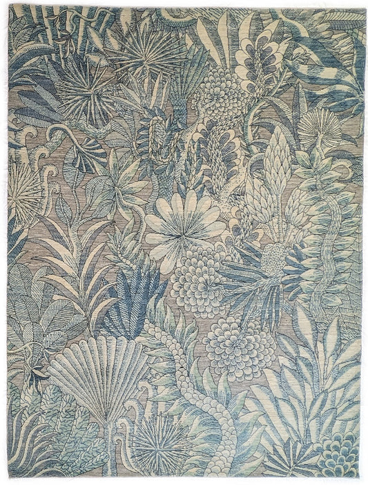 A hand-knotted wool rug with a coastal-inspired floral and plant design in shades of beige, gray, blue, green, and black.