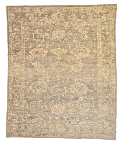 An antique-style beige and neutral-colored rug with a floral and geometric pattern, hand-knotted with low pile.