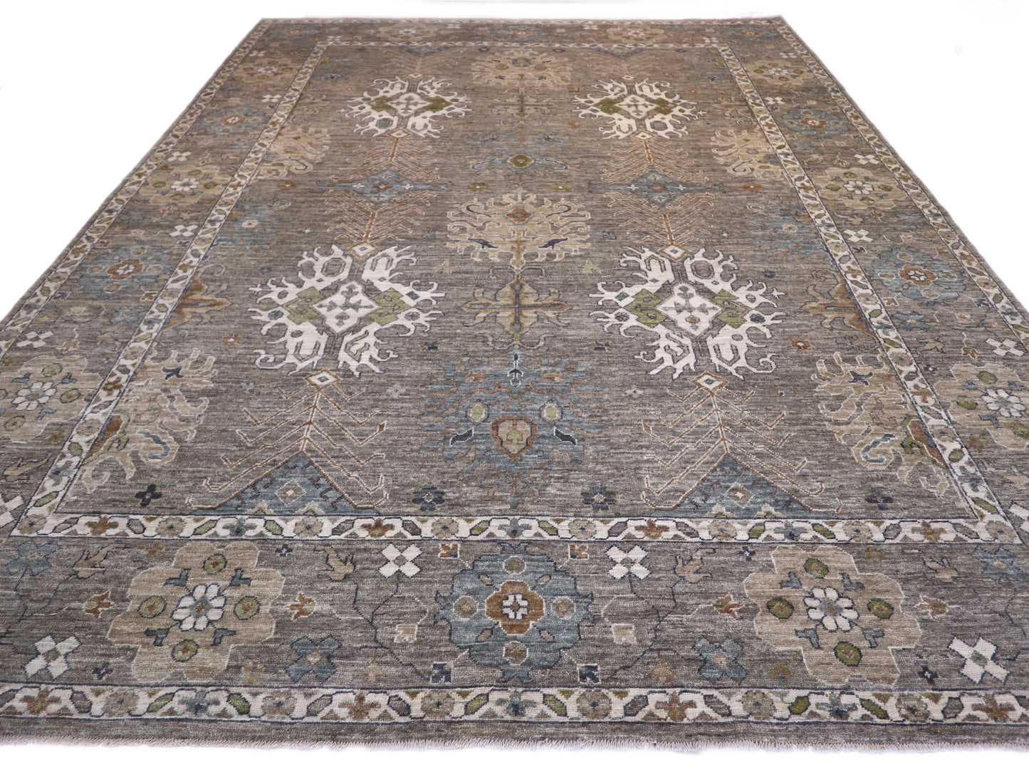 A hand-knotted wool rug with a coastal design in shades of grey, blue, ivory, brown, orange, green, and taupe.