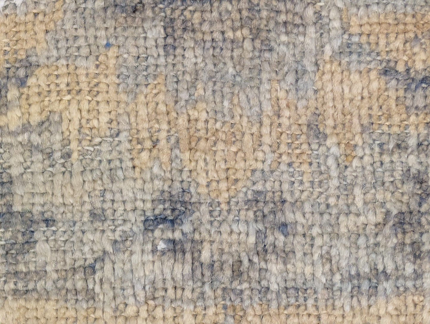 A hand-knotted wool rug with a coastal-inspired design in shades of ivory, beige, grey, blue, smokey green, light yellow, and soft brown.