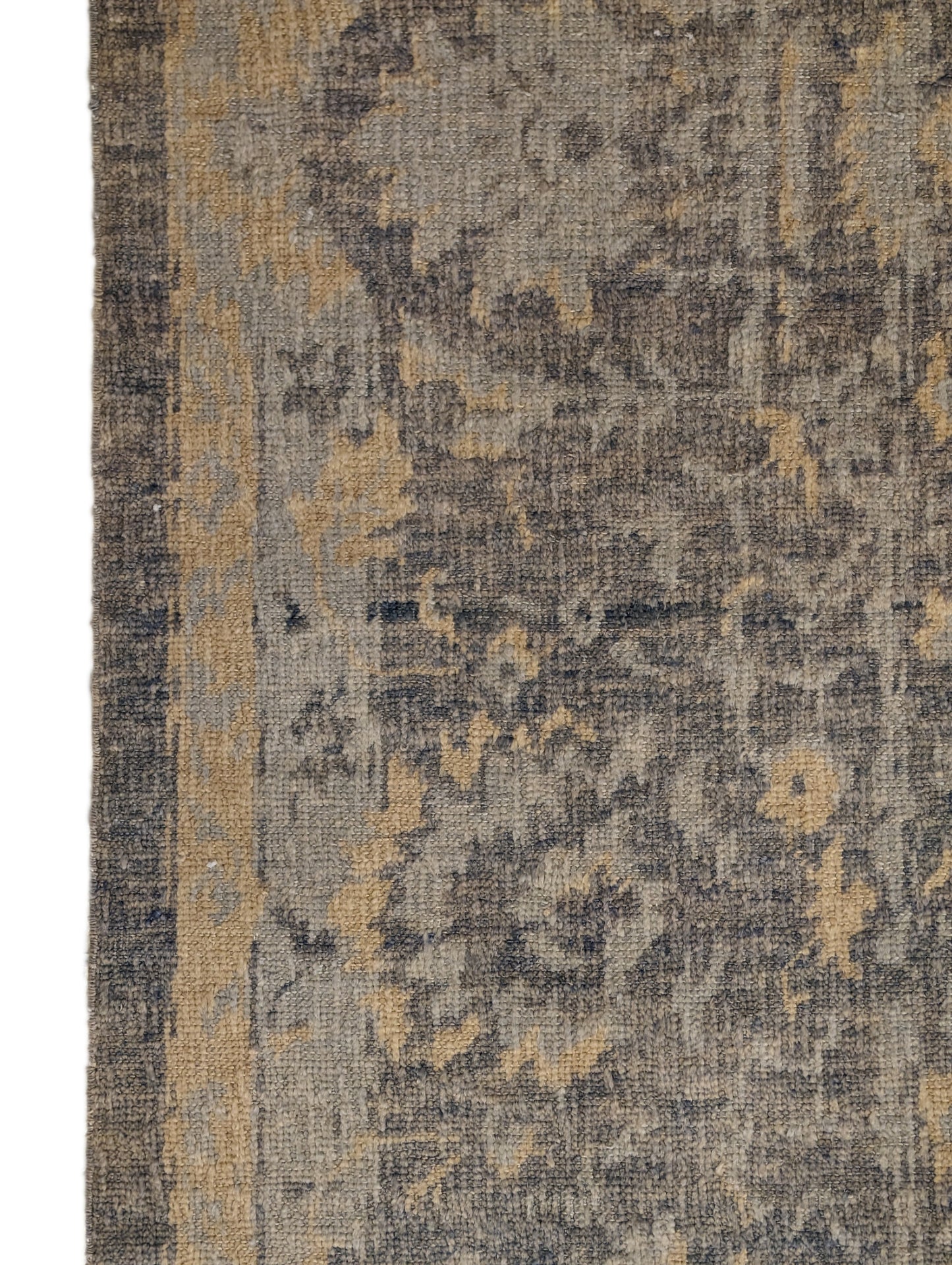 A hand-knotted wool rug with a coastal-inspired design in shades of ivory, beige, grey, blue, smokey green, light yellow, and soft brown.