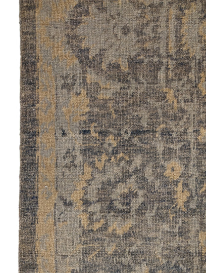 A hand-knotted wool rug with a coastal-inspired design in shades of ivory, beige, grey, blue, smokey green, light yellow, and soft brown.