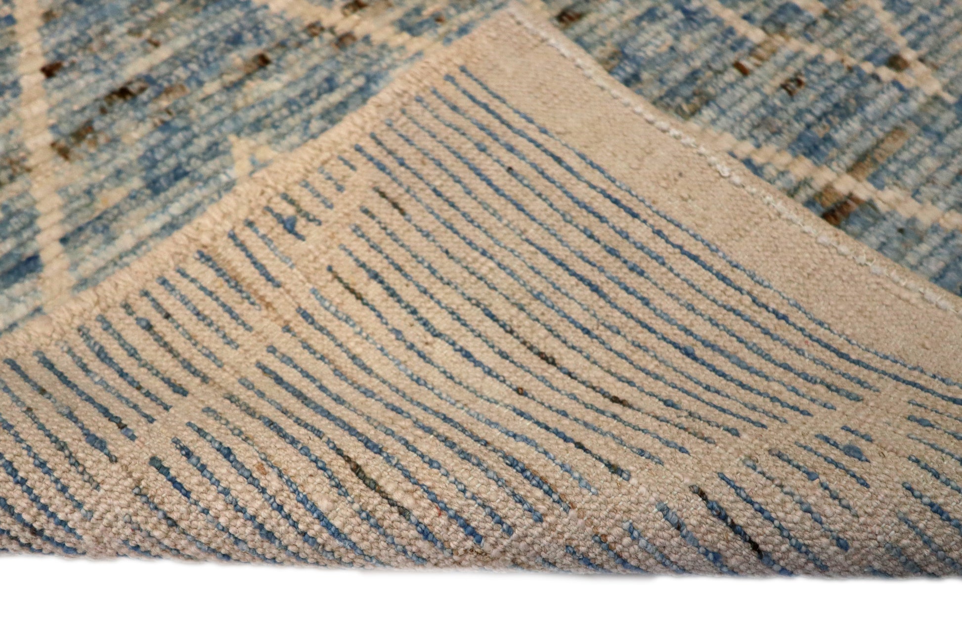 Hand-knotted blue and beige diamond patterned rug with a plush, cozy pile.