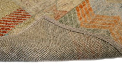 Hand- Knotted multicolored geometric patterned rug with shades of beige, blue, orange, and red.