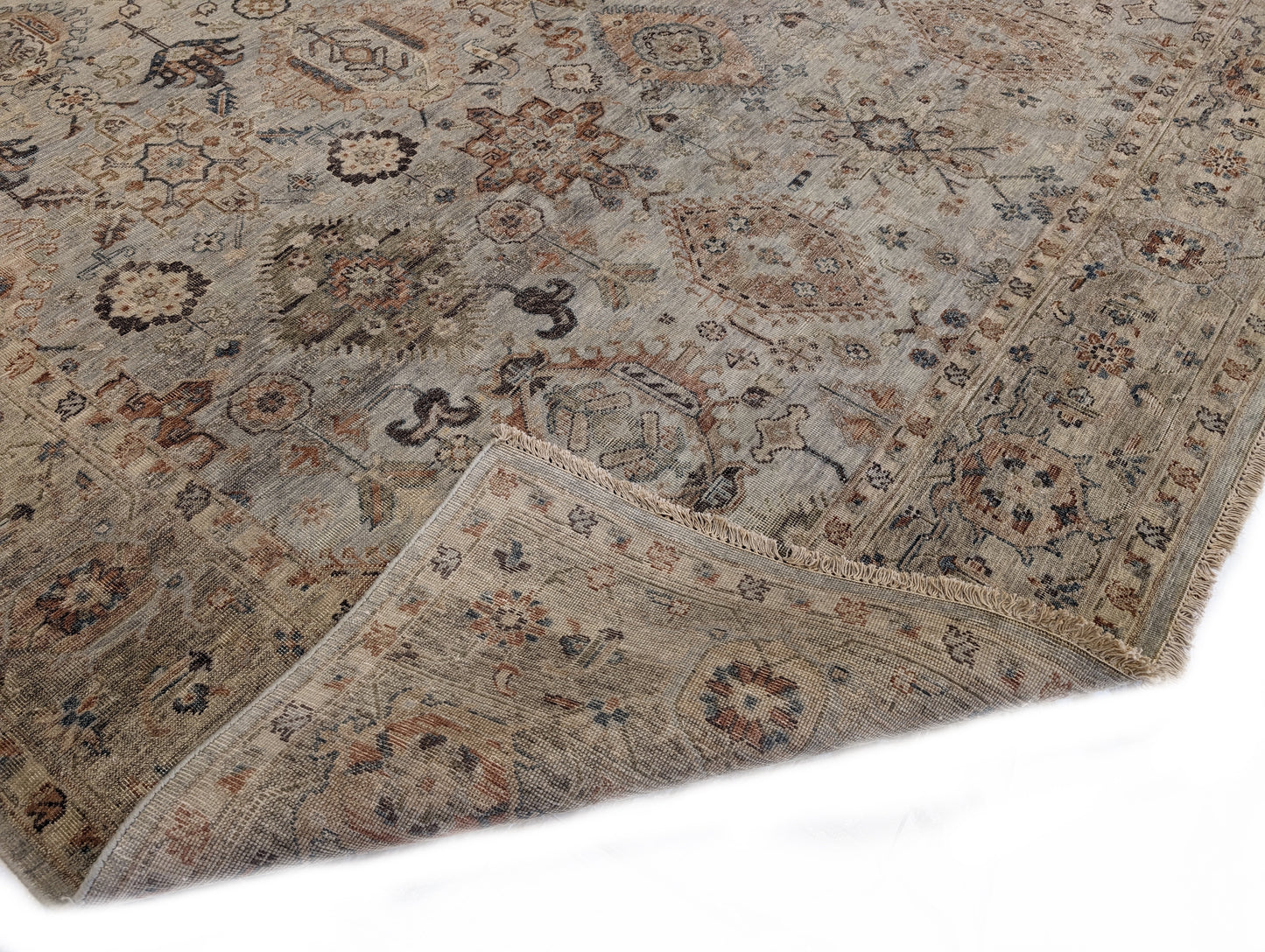 A hand-knotted wool rug with a traditional and coastal design in beige, blue, brown, and gold colors.