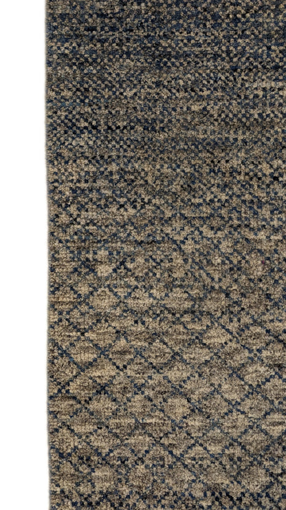 A hand-knotted wool rug with a net pattern in shades of beige, ivory, cream, and blue.