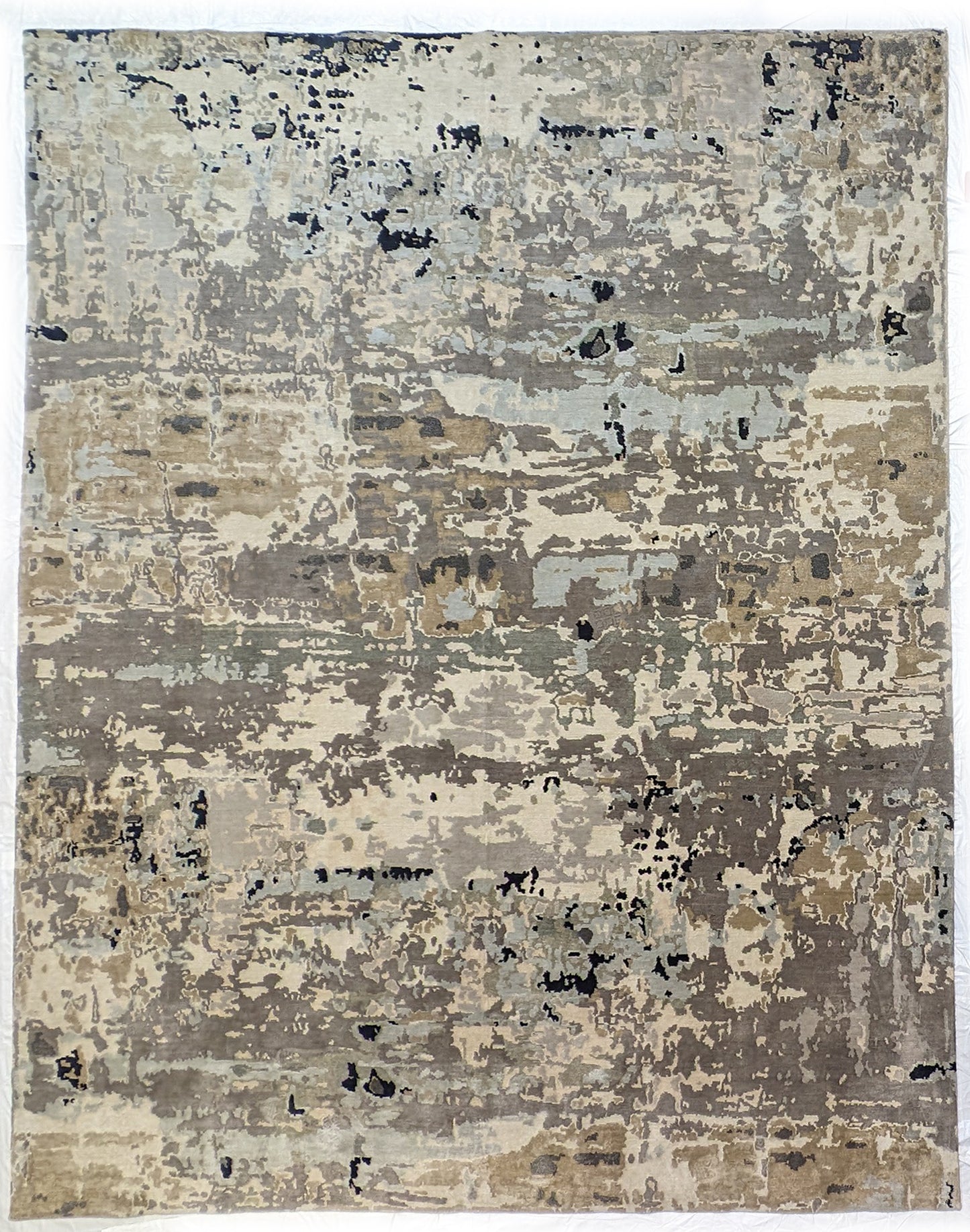 A luxurious coastal-themed rug featuring a blend of beige, gray, blue, and green colors with a textured and rugged texture. Wool and silk. 