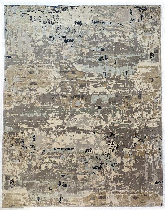 A luxurious coastal-themed rug featuring a blend of beige, gray, blue, and green colors with a textured and rugged texture. Wool and silk. 