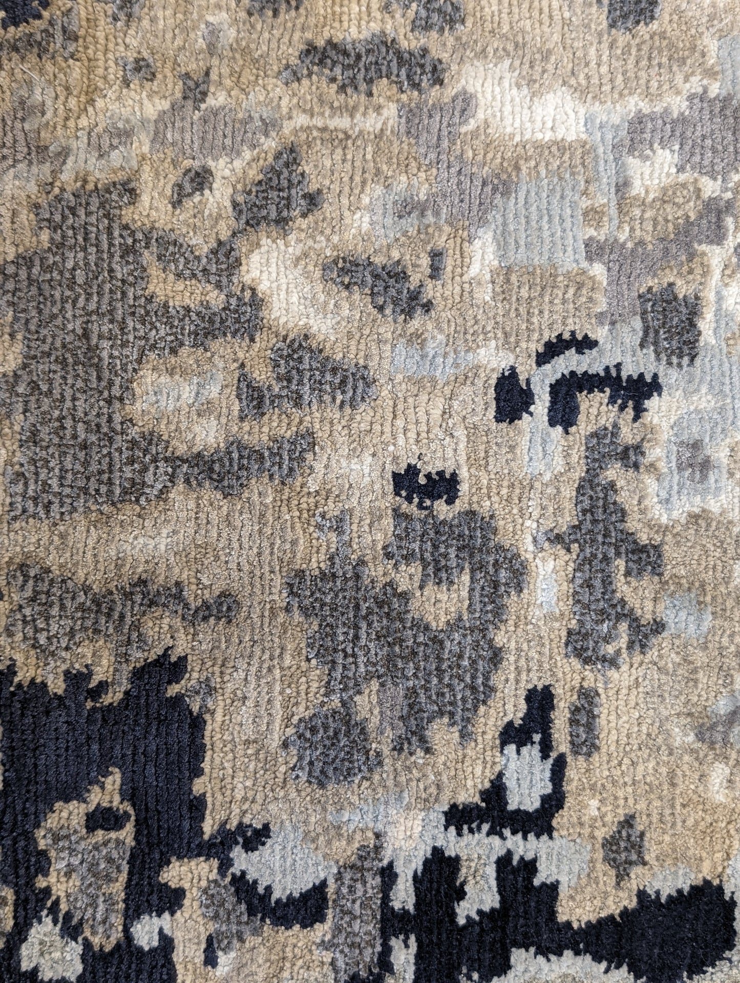 A luxurious coastal-themed rug featuring a blend of beige, gray, blue, and green colors with a textured and rugged texture. Wool and silk. 