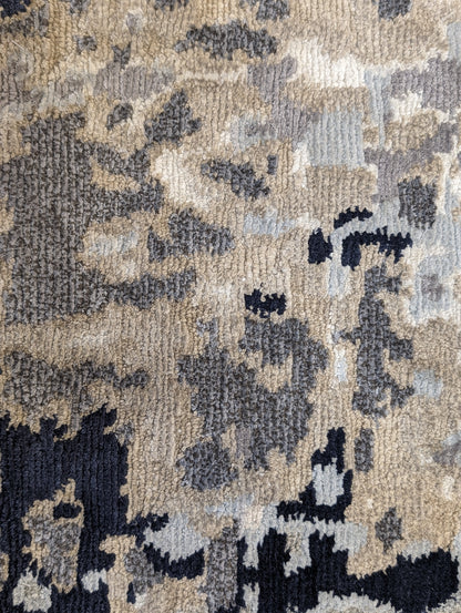 A luxurious coastal-themed rug featuring a blend of beige, gray, blue, and green colors with a textured and rugged texture. Wool and silk. 