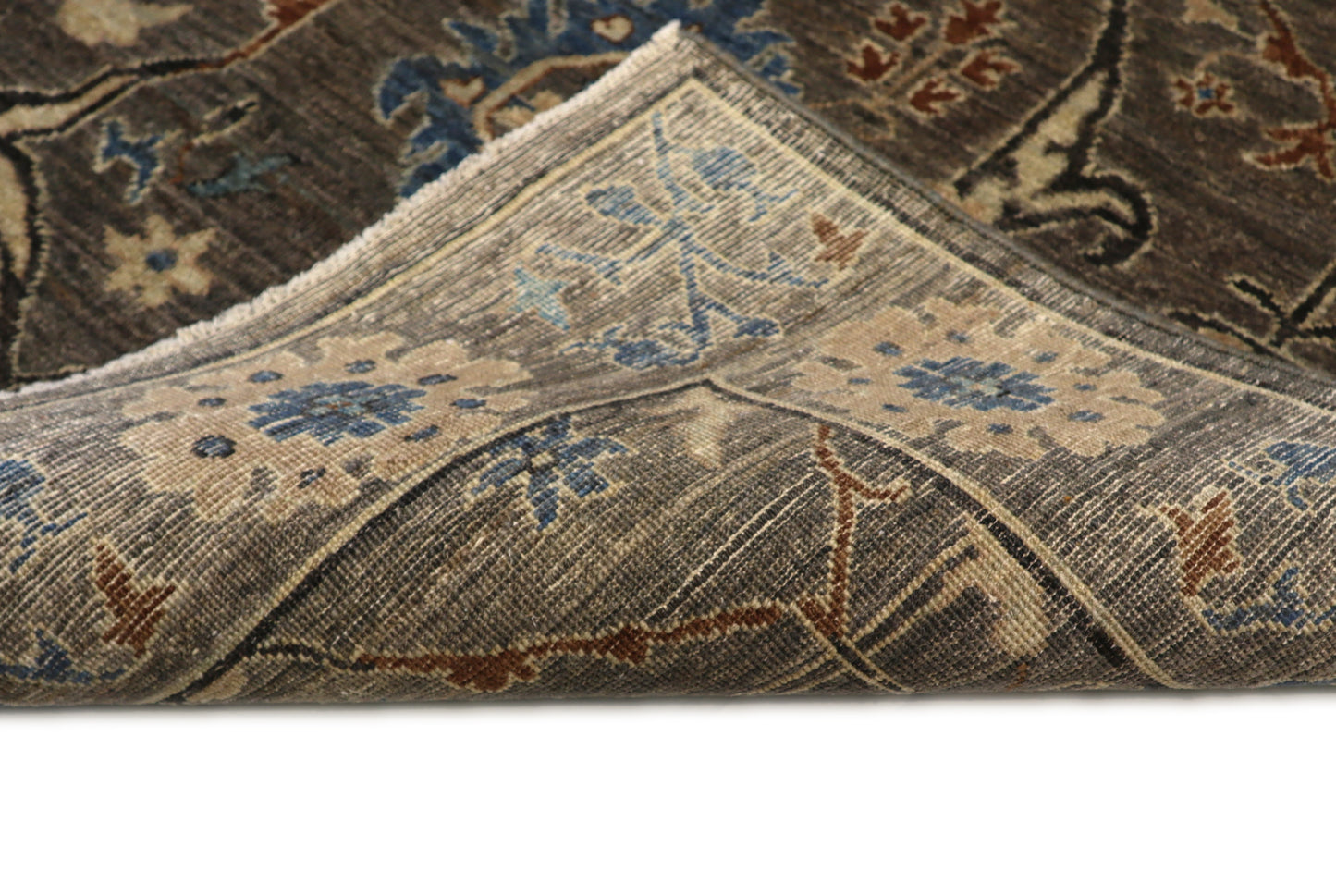 Hand-knotted decorative wool rug with a luxurious pile in misty gray and weathered seabed tones with Atlantic blue and rust accents.