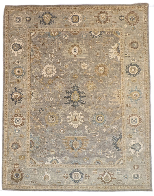 A hand-knotted wool rug featuring a coastal pattern with shades of beige, blue, brown, bronze, gold, ivory, and grey.