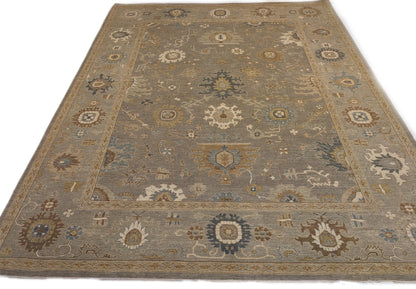 A hand-knotted wool rug featuring a coastal pattern with shades of beige, blue, brown, bronze, gold, ivory, and grey.