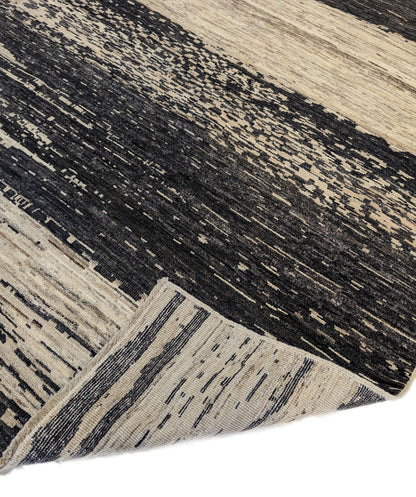 A hand-knotted wool rug with a cozy pile, featuring natural tones of ivory, beige, gray, and brown.