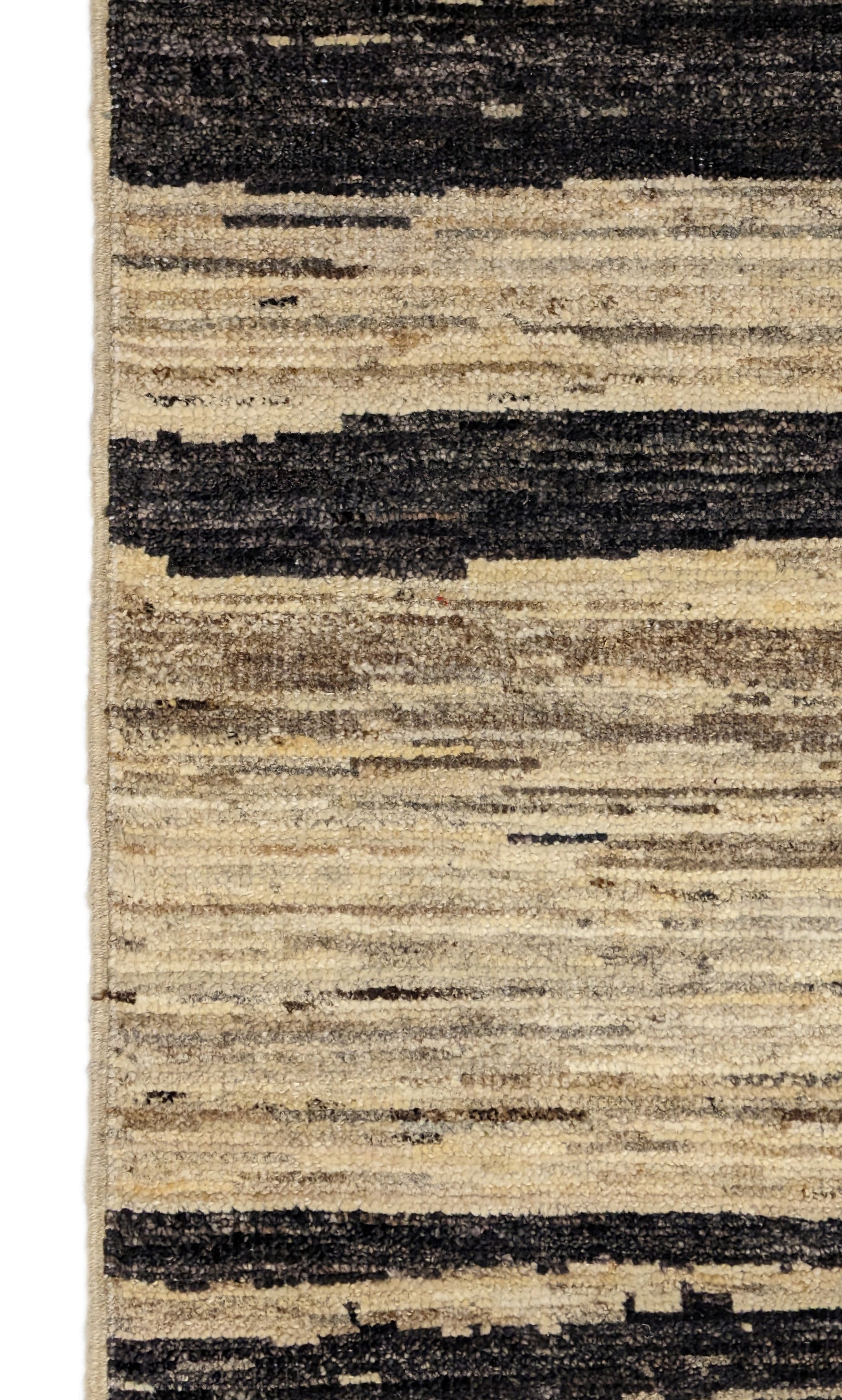 A hand-knotted wool rug with a cozy pile, featuring natural tones of ivory, beige, gray, and brown.