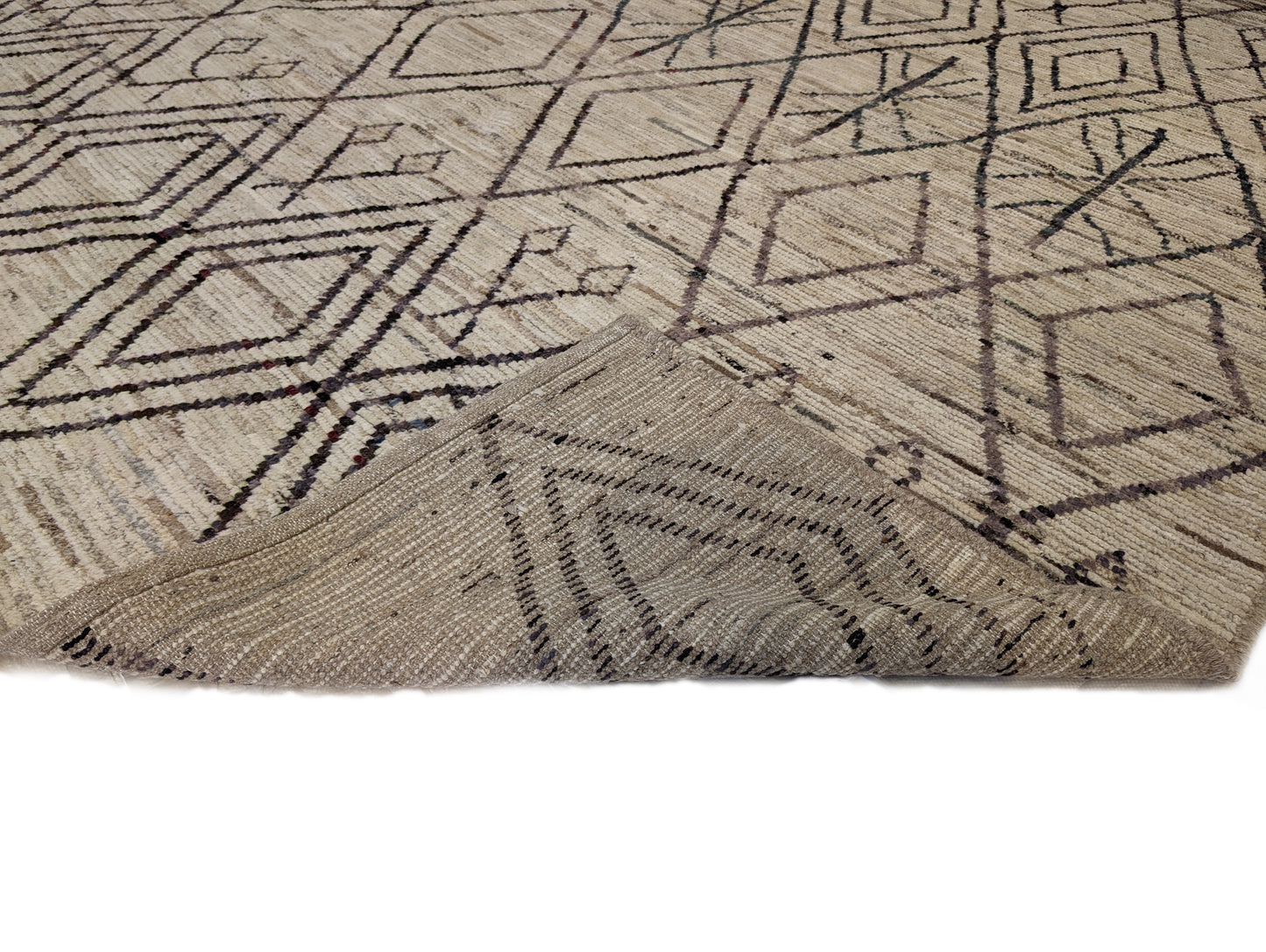 A hand-knotted wool rug with a geometric pattern in natural tones of beige, brown, and gray. Cozy pile.