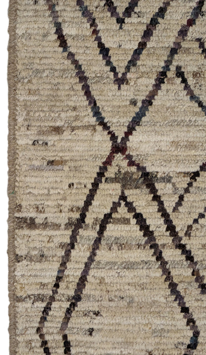 A hand-knotted wool rug with a geometric pattern in natural tones of beige, brown, and gray. Cozy pile.