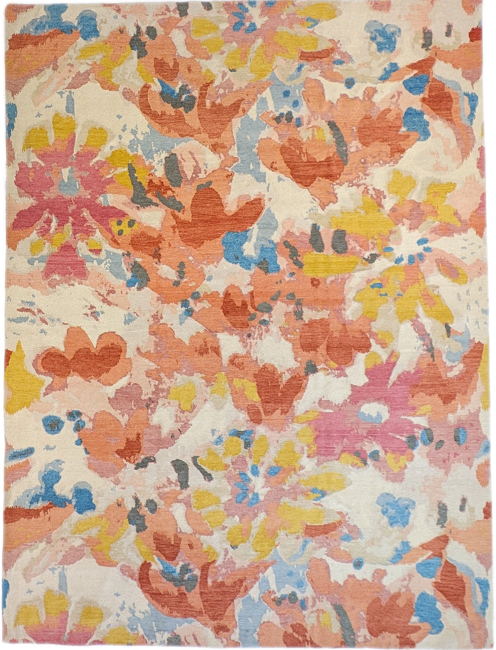 A hand-knotted rug with a floral pattern in a mix of pink, orange, yellow, blue, and gray hues.