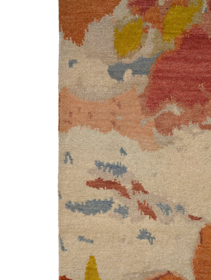 A hand-knotted rug with a floral pattern in a mix of pink, orange, yellow, blue, and gray hues.
