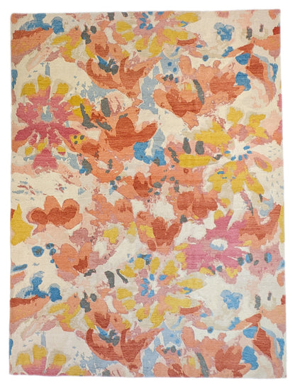 A hand-knotted rug with a floral pattern in a mix of pink, orange, yellow, blue, and gray hues.