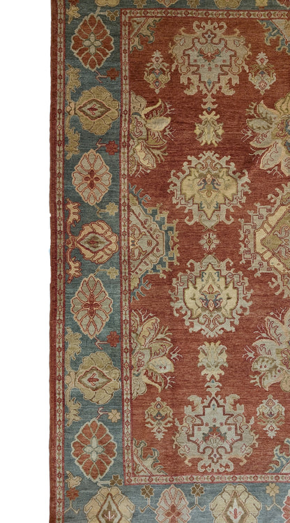 A handmade rug with a classic geometric pattern featuring a mix of rosy pink, golden yellow, blue, beige, and ivory colors.