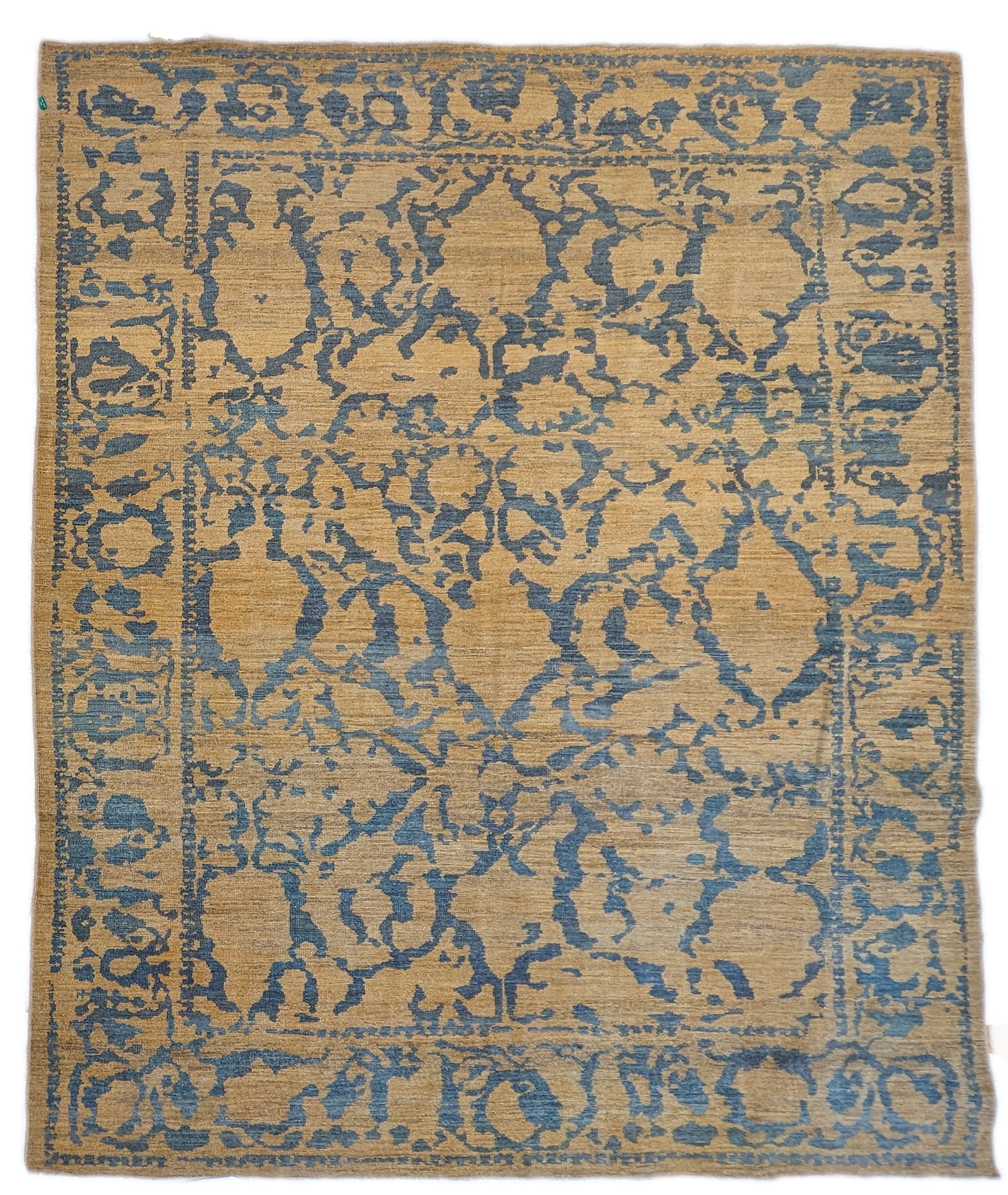 A hand-knotted wool rug with a geometric pattern in natural jute brown and muted aquamarine undertones. Low pile. 