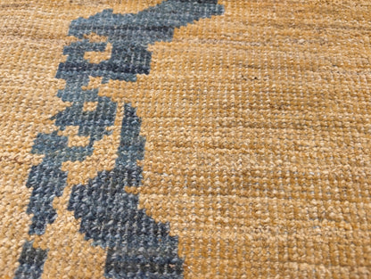 A hand-knotted wool rug with a geometric pattern in natural jute brown and muted aquamarine undertones. Low pile. 