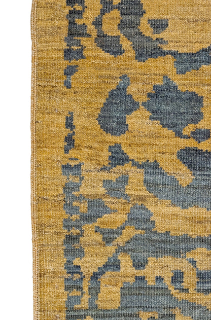 A hand-knotted wool rug with a geometric pattern in natural jute brown and muted aquamarine undertones. Low pile. 