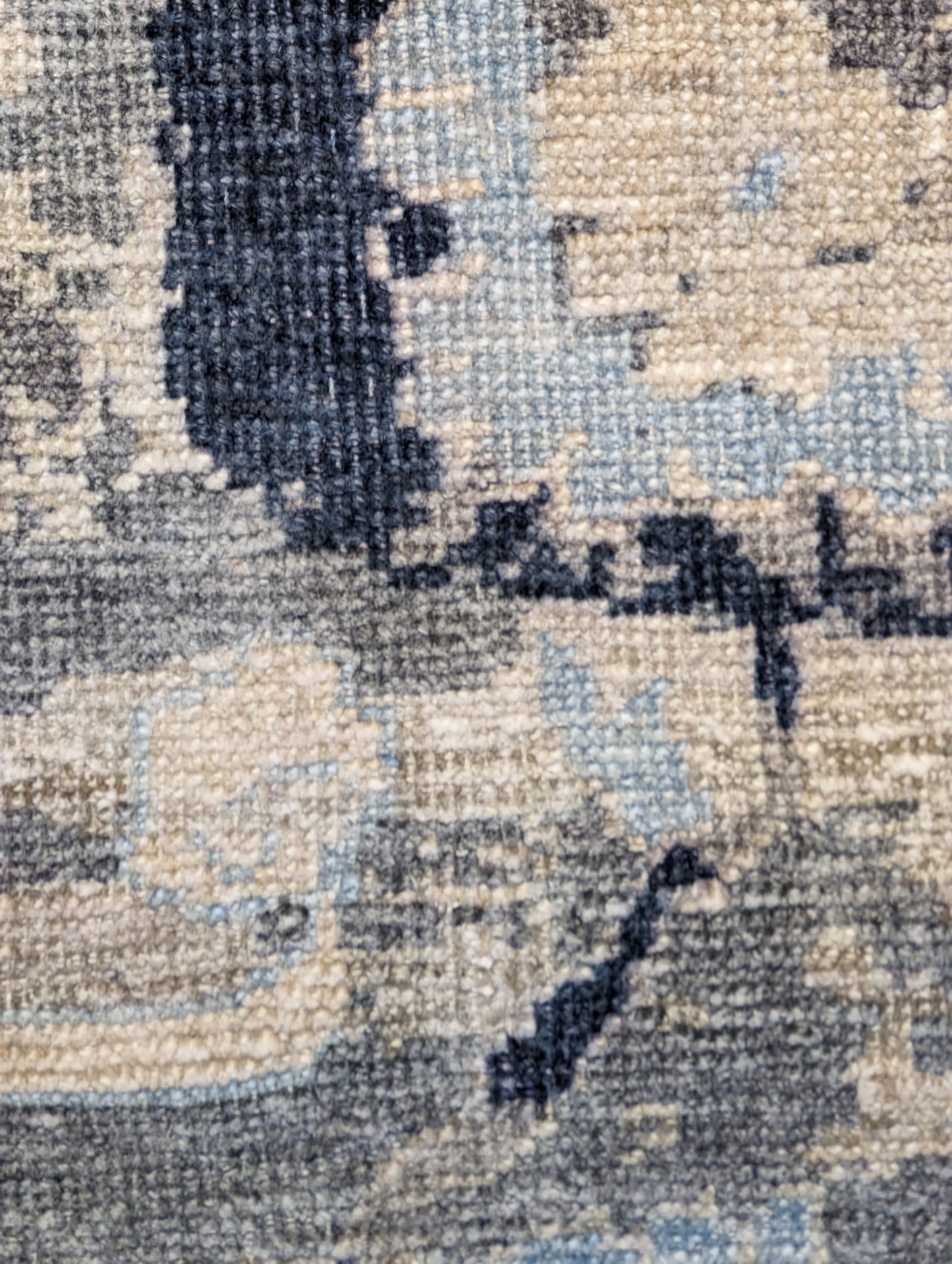 A hand-knotted silk rug with a coastal palette of grey, ivory, navy, light blue, and sandy taupe, featuring traditional and contemporary design elements.