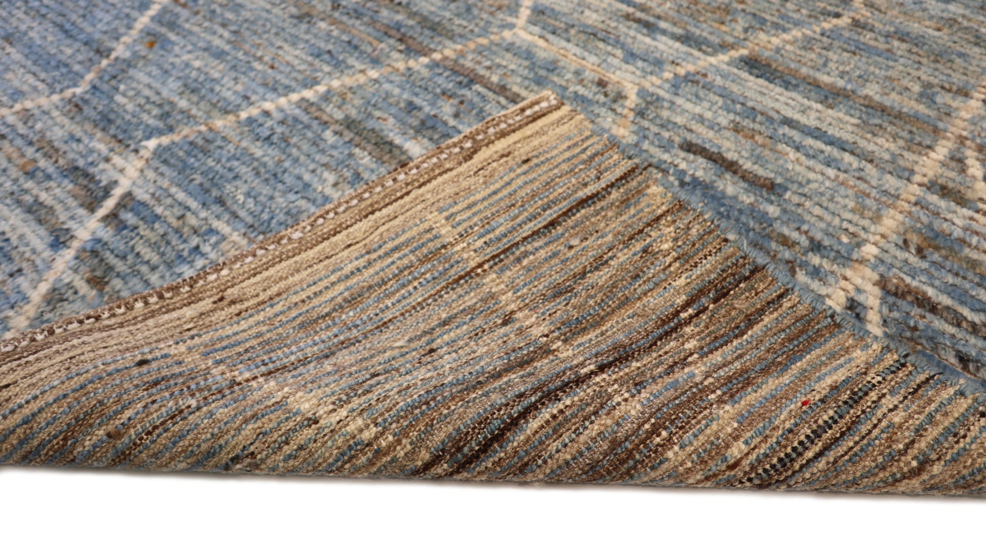 Hand-knotted geometric wool rug with a high pile and large knots in blue, ivory, beige, grey, and brown.