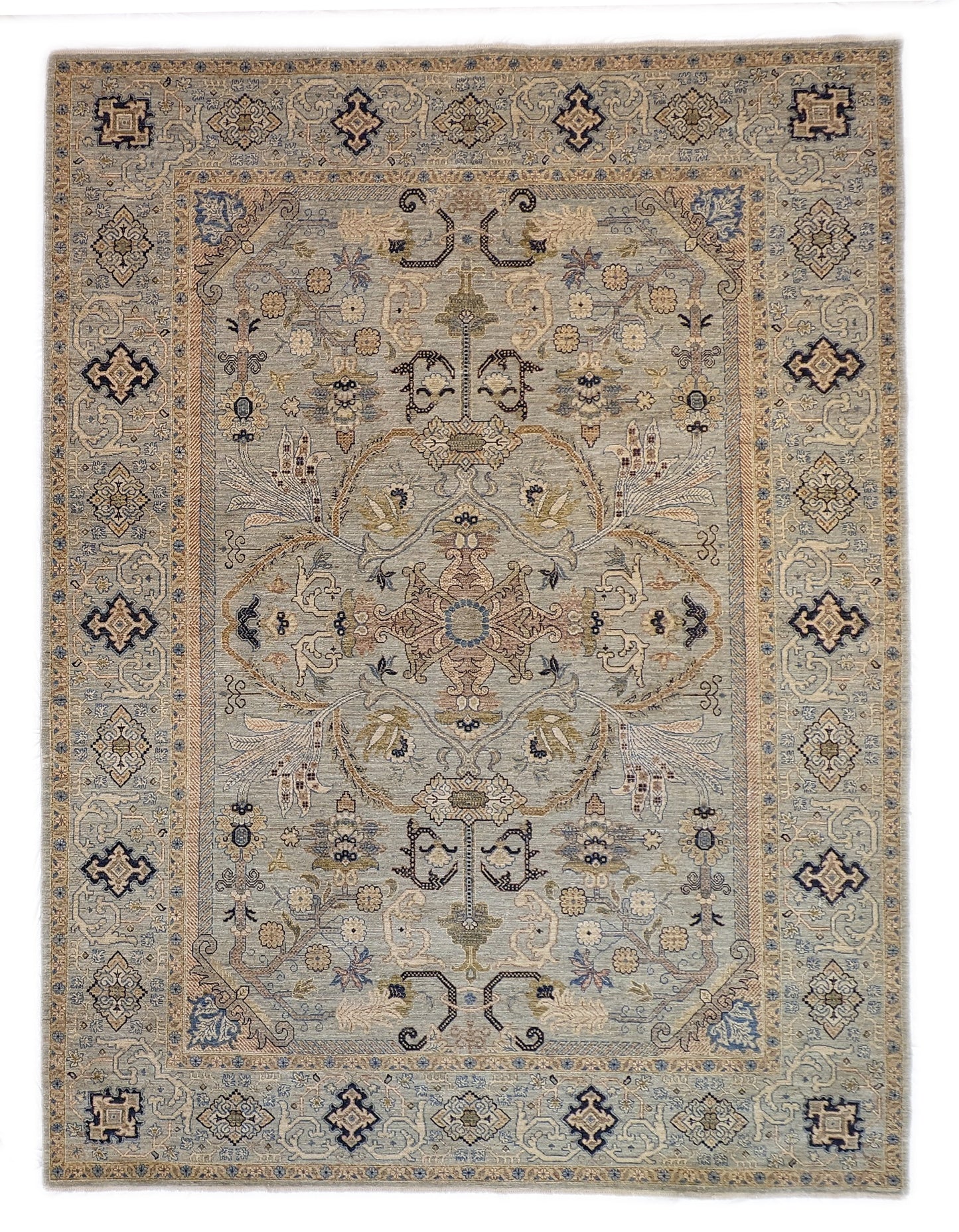A hand-knotted wool rug with a coastal palette of beige, navy, rosy pink, blue, gold, and ivory colors, featuring intricate traditional and contemporary patterns.