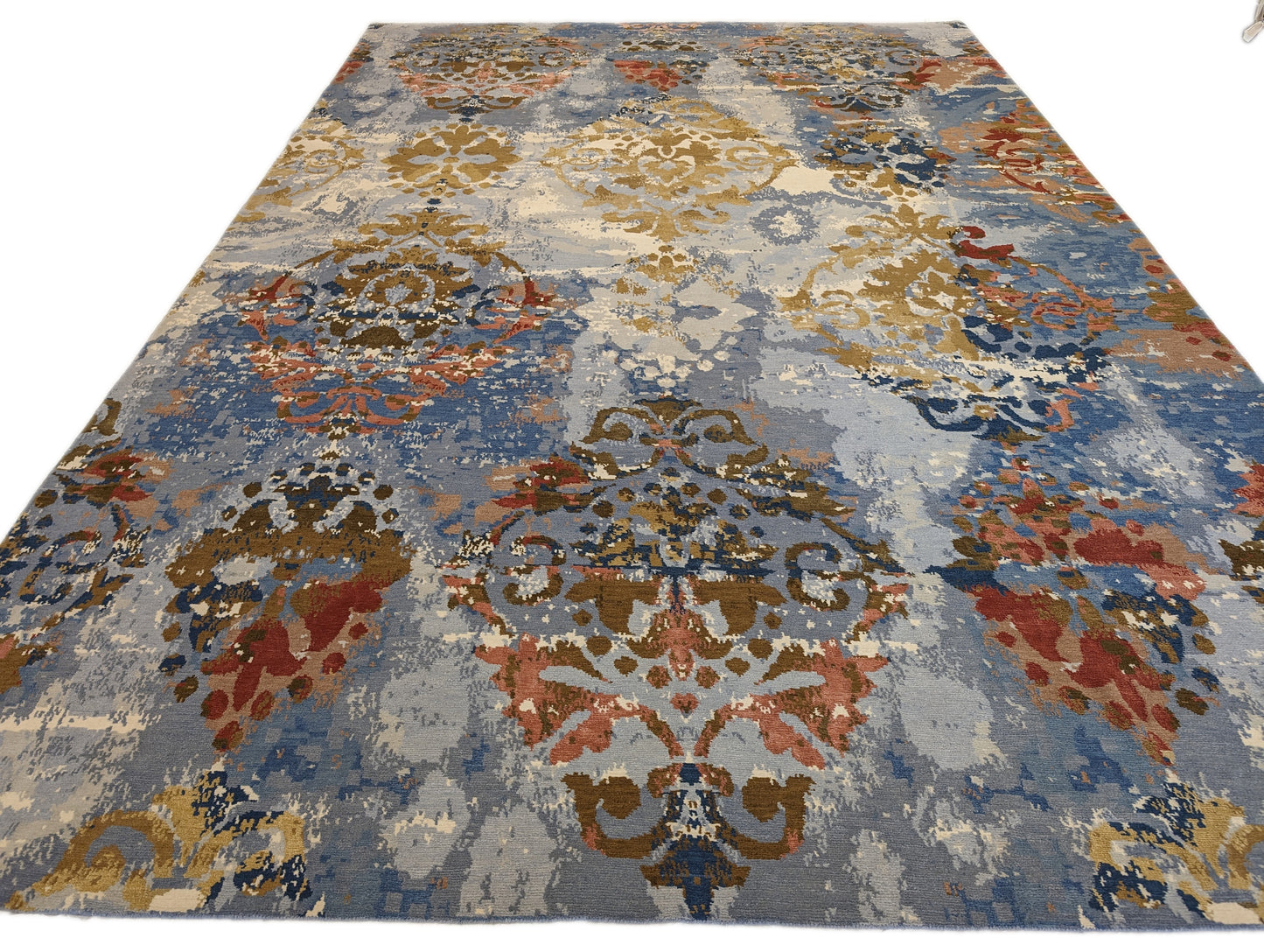 A hand-knotted rug with a luxurious blend of knots, featuring a palette of blues, salmon, ivory, brown, and gold. Wool and silk. 
