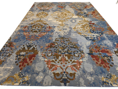 A hand-knotted rug with a luxurious blend of knots, featuring a palette of blues, salmon, ivory, brown, and gold. Wool and silk. 
